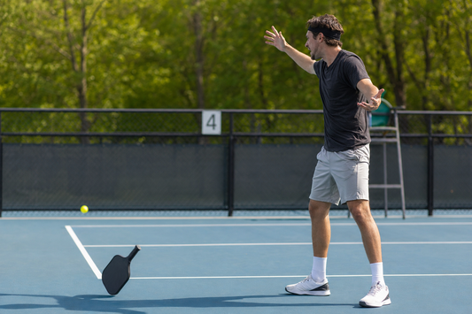 Joueur de pickleball ayant lancé son paddle au sol après une faute, scène humoristique