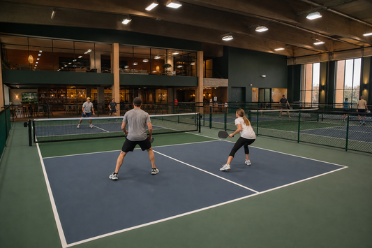 Salle de pickleball indoor premium avec plusieurs courts couverts dans un batiment moderne